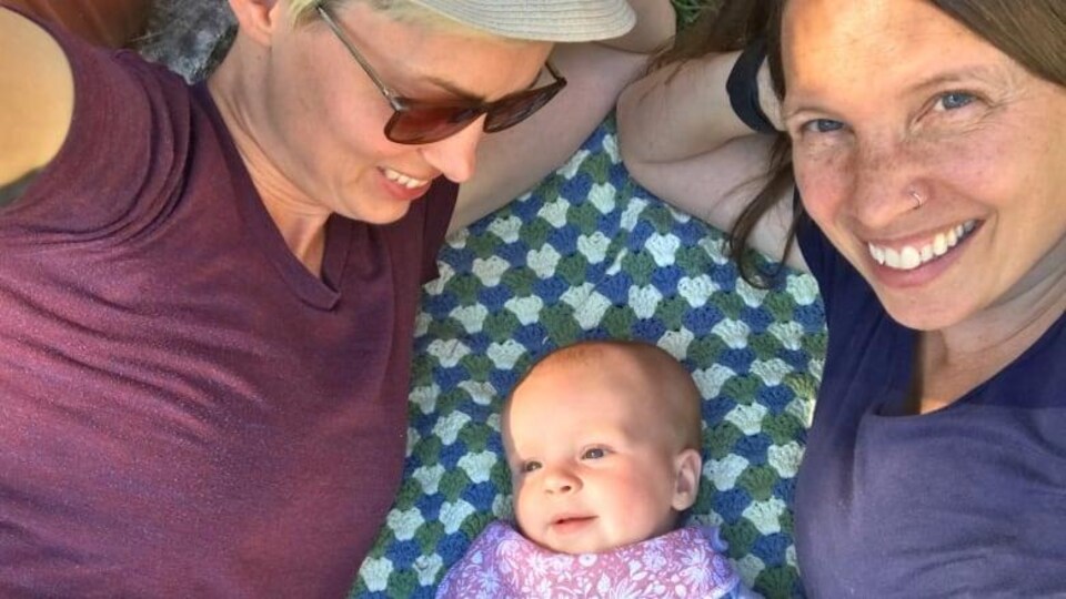 Deux femmes et un bébé couchés.