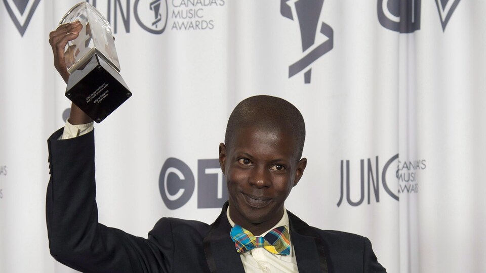 Karim Ouellet sourit en brandissant le prix Juno qu'il a reçu en 2014 pour l'album francophone de l'année.