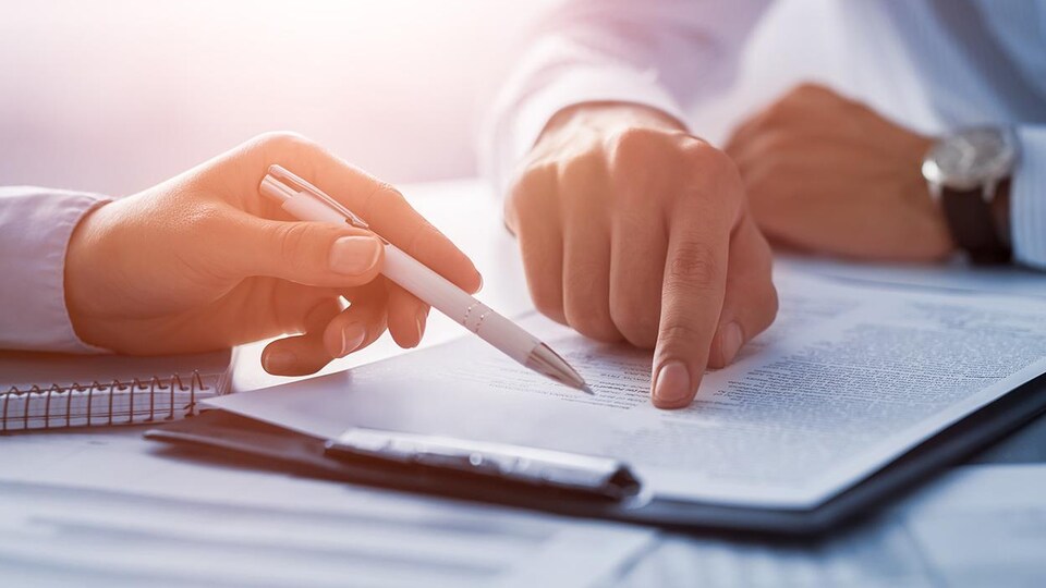 Deux personnes qui signent un contrat.