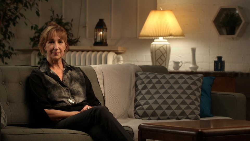 Elle est assise dans un canapé.
