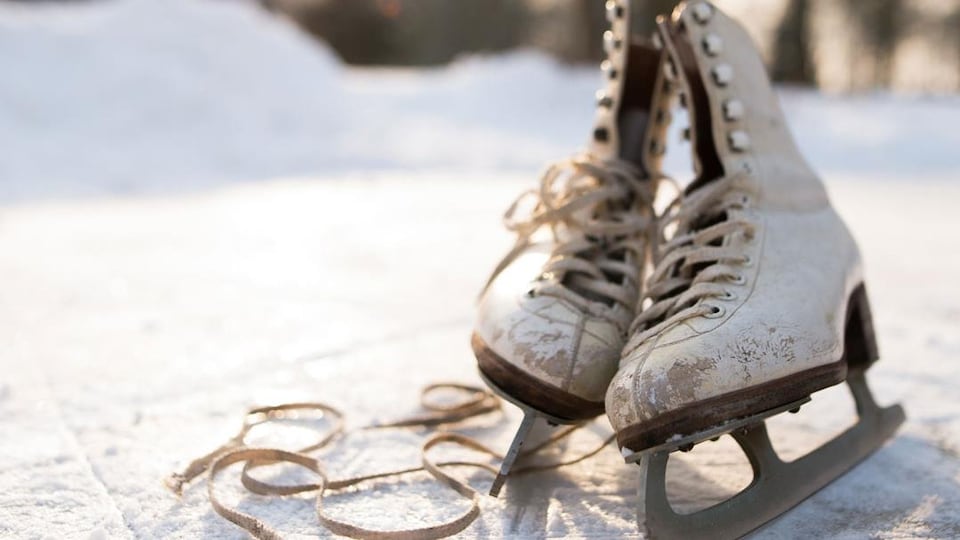 Photo d'une vielle paire de patins à glace sur une patinoire extérieure.