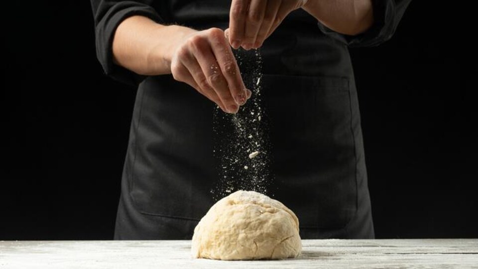 Un cuisinier avec de la pâte.