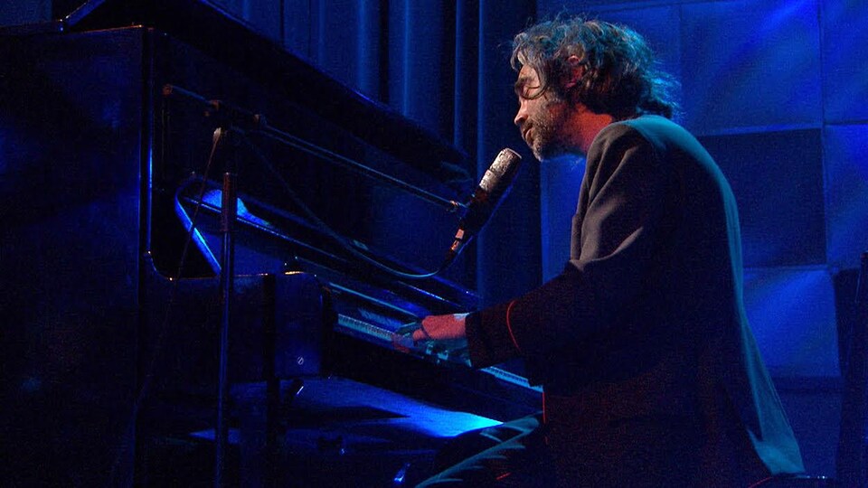 Patrick Watson est au piano, sur un plateau de télévision.