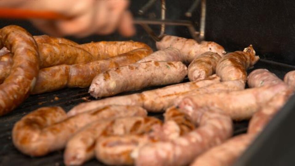 Les saucisses sont grillées sur le barbecue.
