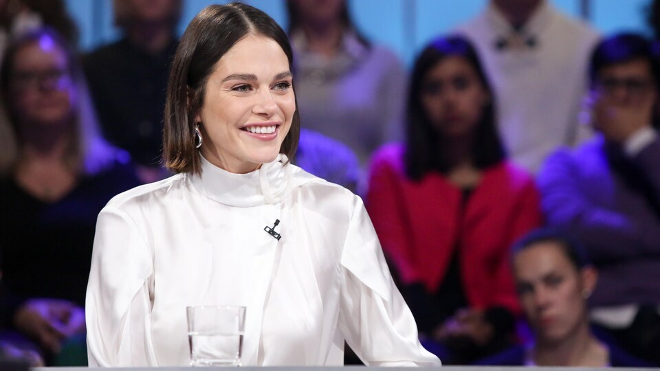 Maripier Morin, souriante, est assise à la table des invités.