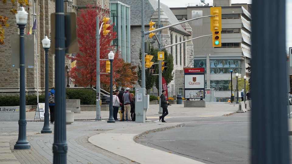 Des étudiants attendent de traverser l'avenue University sur le campus.