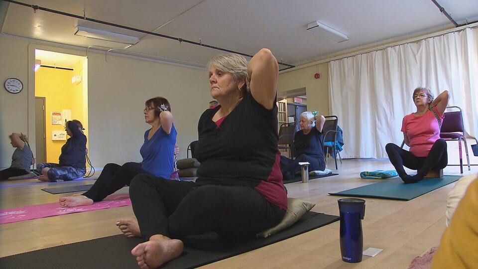 Des aînés de l'Université du 3e âge à une session de yoga.