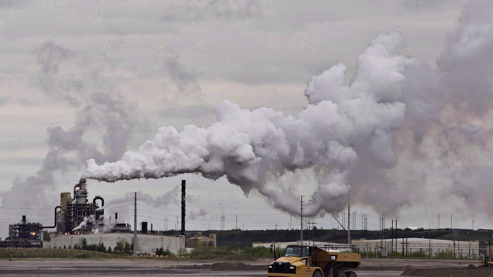 Un camion travaille près de l'installation d'extraction des sables bitumineux de Syncrude près de la ville de Fort McMurray, en Alberta, le 1er juin 2014.