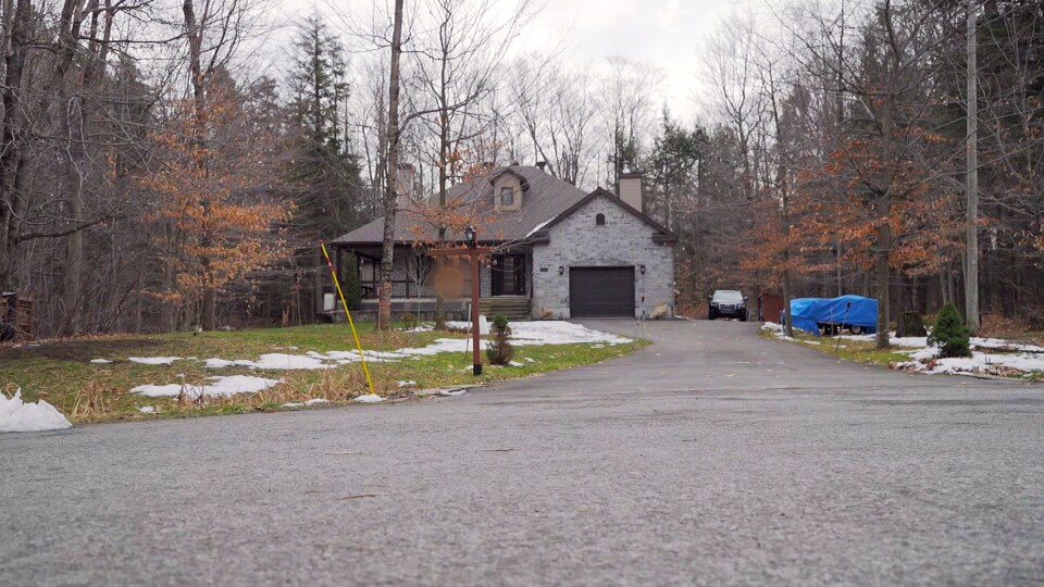 La maison de Marc Lalande et Suzanne Ouellet a un garage attenant et elle est entourée d'arbres.