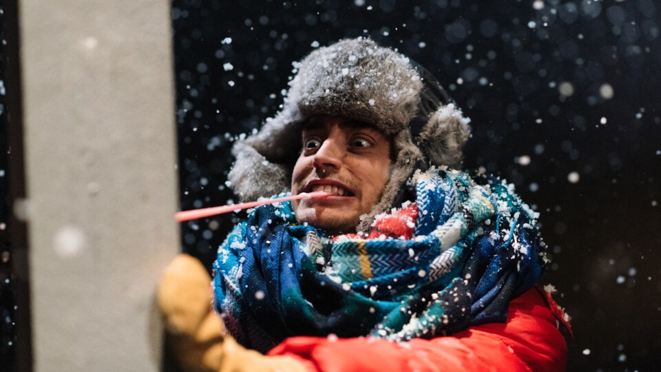 Un homme porte une tuque et fait une grimace.