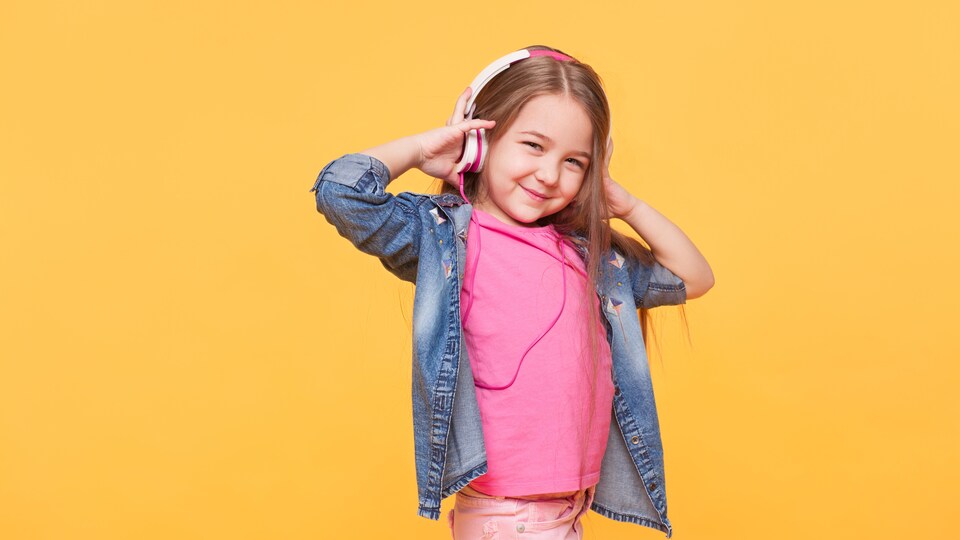 Une petite fille écoute de la musique.