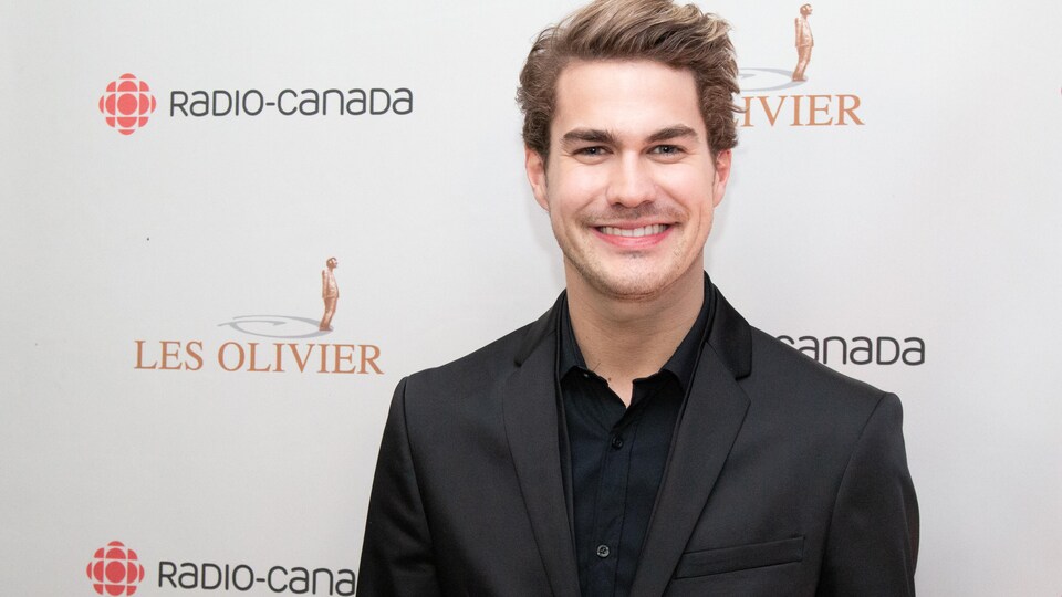 Il sourit sur le tapis rouge du Gala Les Olivier