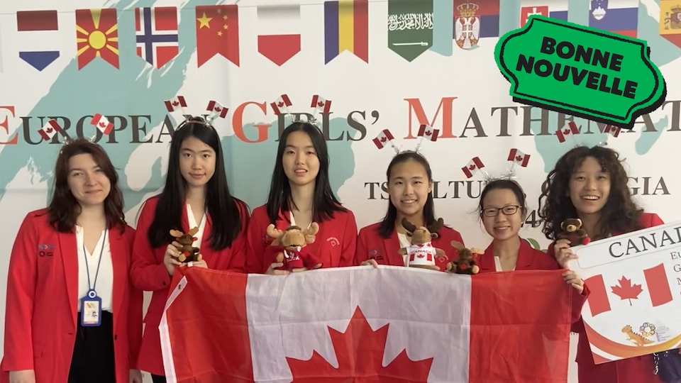 Six jeunes femmes avec des médailles et des toutous d'orignaux tiennent un drapeau canadien, à côté d'un collant Bonne nouvelle de MAJ.