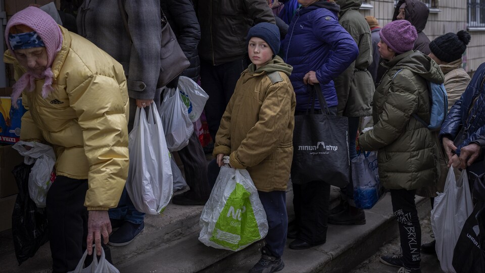 Sergei, an 11-year-old child, is waiting his turn to receive food donations at a humanitarian distribution in Bucha, outside kyiv, Tuesday, April 19, 2022.