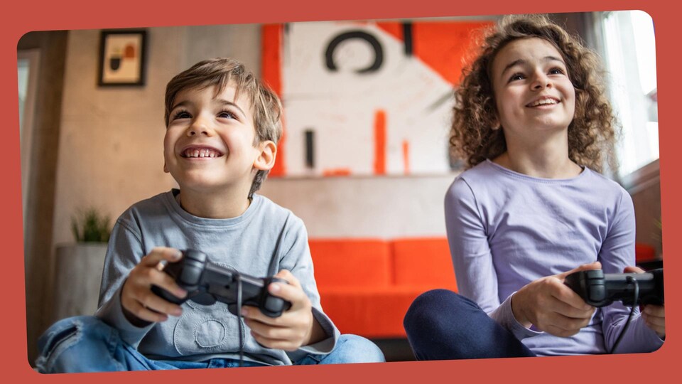 Deux enfants jouent avec une console de jeux vidéo. 