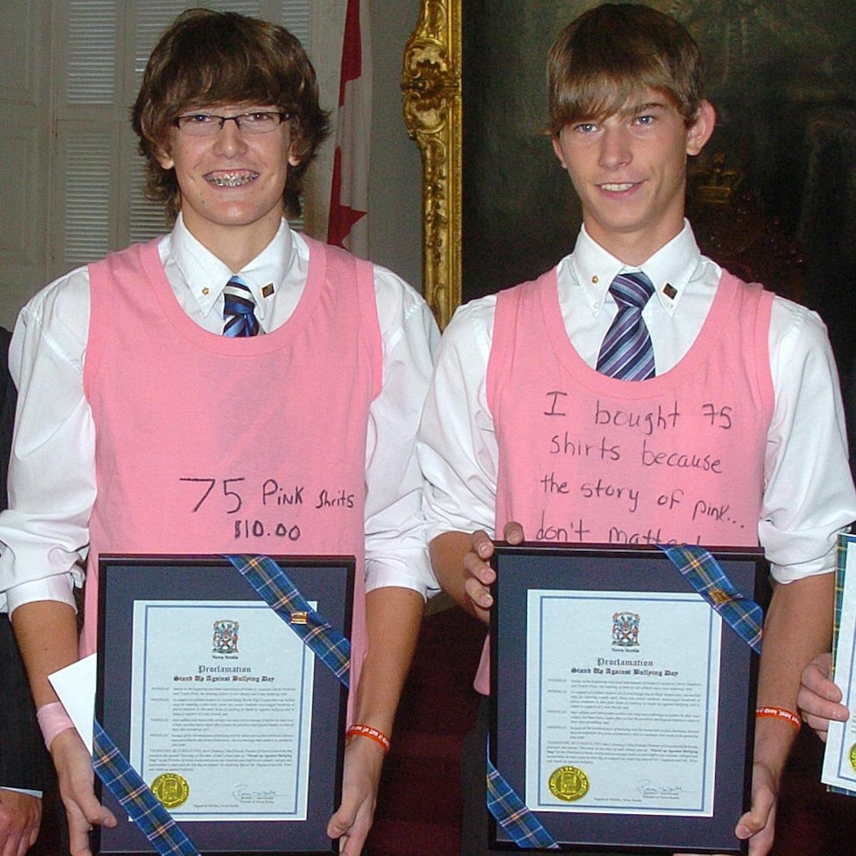 Deux garçons portent des chandails roses et tiennent un prix de distinction de la Nouvelle-Écosse.