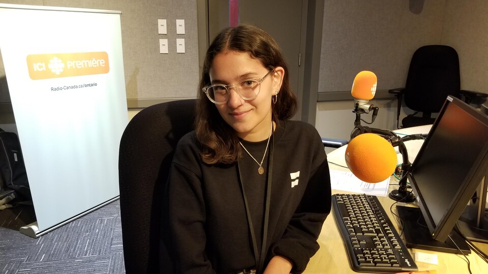 L'étudiante Skyler Jain assise dans studio devant deux micros