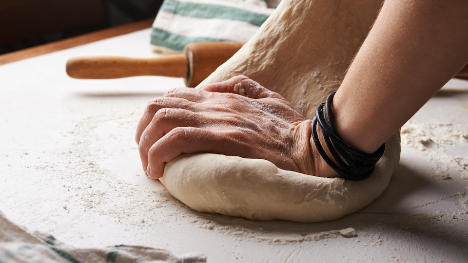 Pétrissage de pain sur une table.