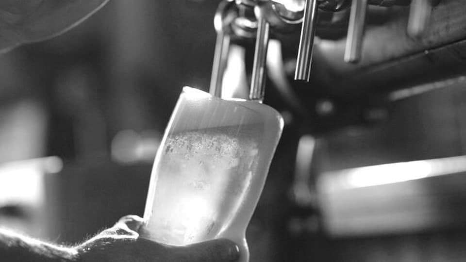 Un barman rempli une bière en fut.