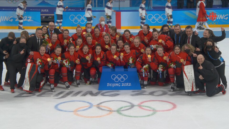 Elles sont regroupées sur la glace pour la photo d'équipe avec leur médaille d'or. 