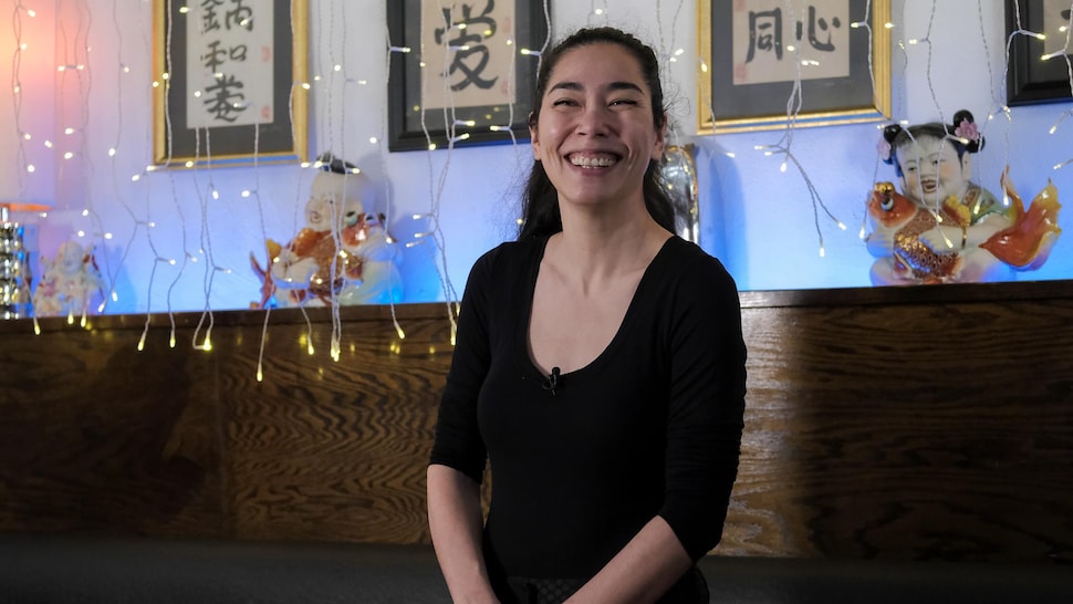 Une restauratrice d'origine asiatique sourit à la caméra