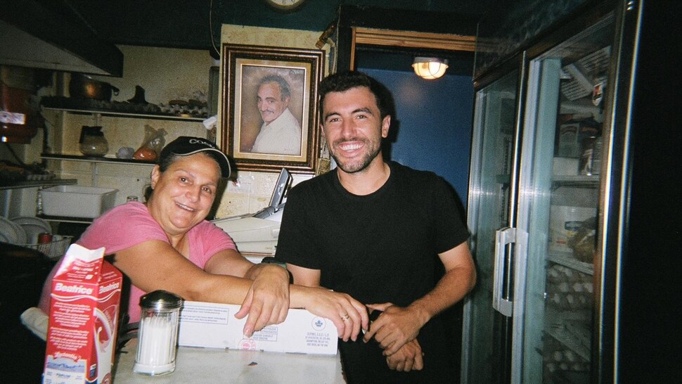 David Minicucci et une employée du restaurant Fameux Cosmos sourient en regardant la caméra. 