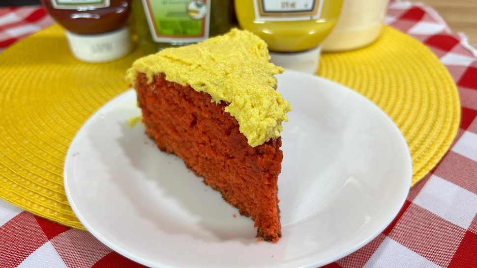 Une part de gâteau rouge et jaune dans une assiette.