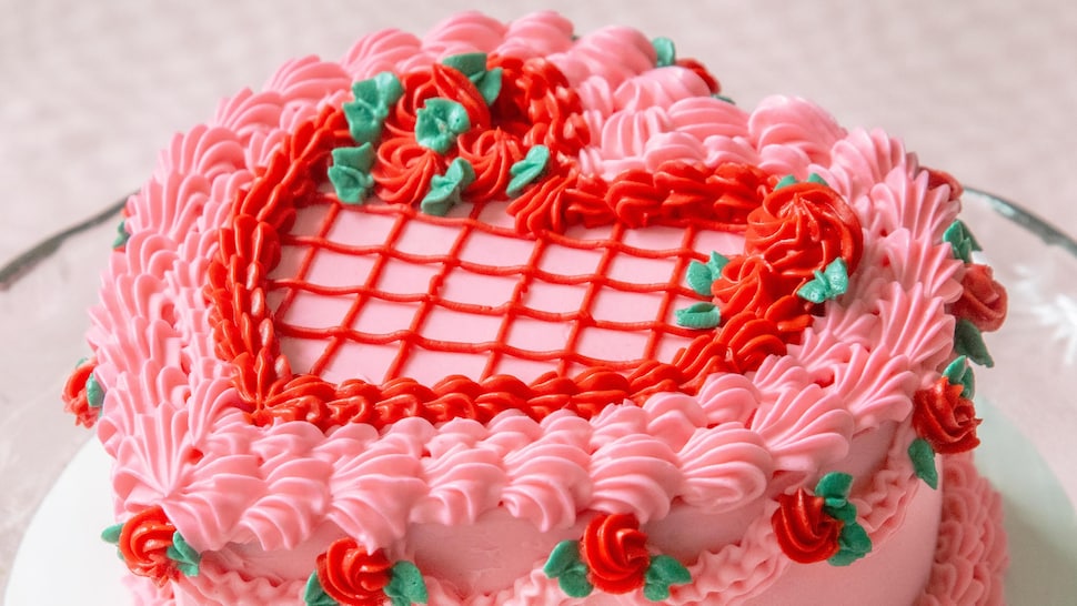Un gâteau en forme de cœur décoré de roses. 