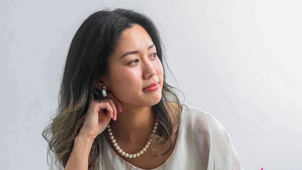 Linh Le Kim est assise à une table devant une soupe dessert. 