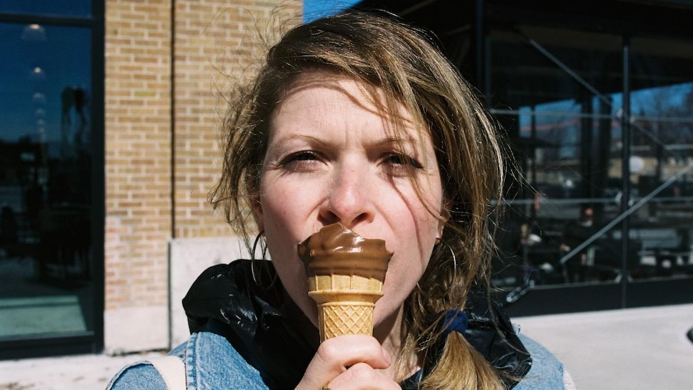 Karine Jacques mange une crème glacée trempée dans le chocolat. 