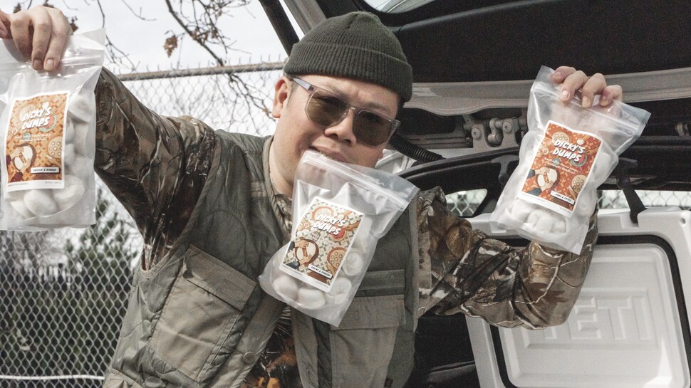 Dickson Li tient des sacs remplis de raviolis asiatiques dans ses mains. 