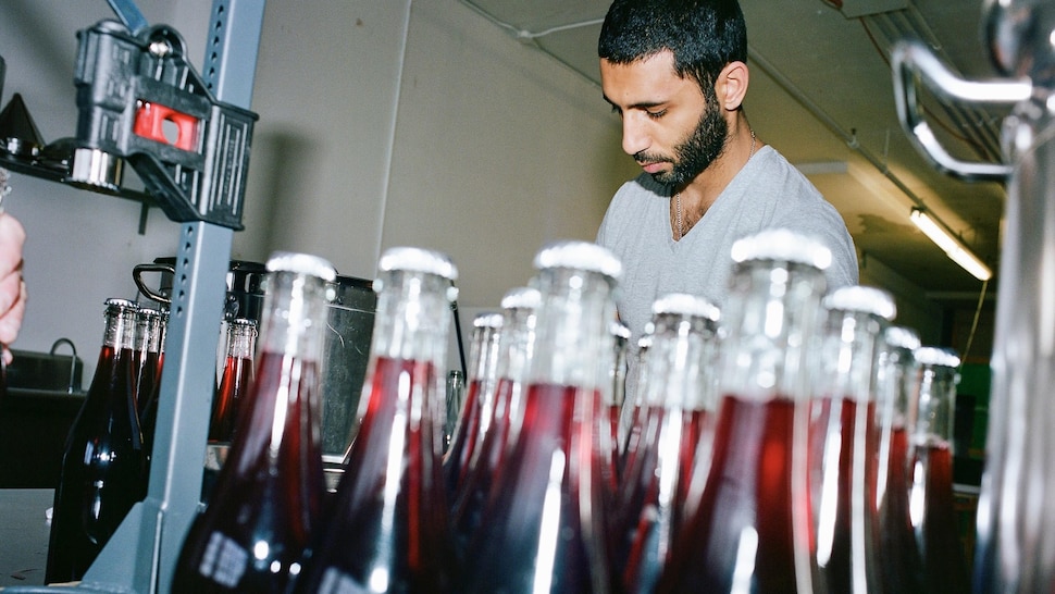 Bashar Odeh remplit des bouteilles de jus d'hibiscus. 