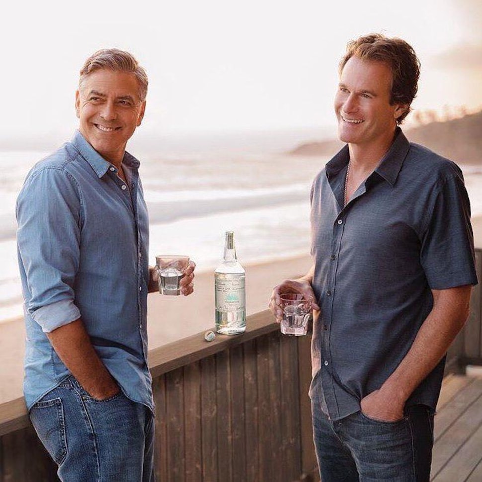 Deux hommes tenant un verre sur le bord d'une plage.