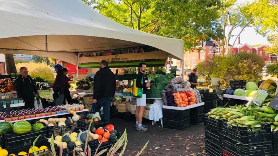 Café à la main, une personne fait ses courses au marché. 