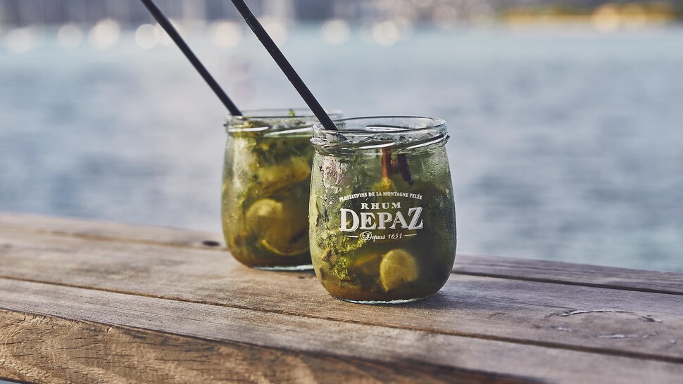 Deux cocktails sur un bar en bois au bord de la mer.