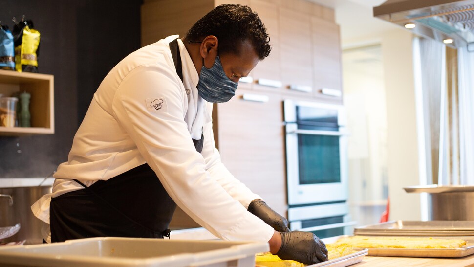 Un homme coupe en cubes des oeufs cuits.