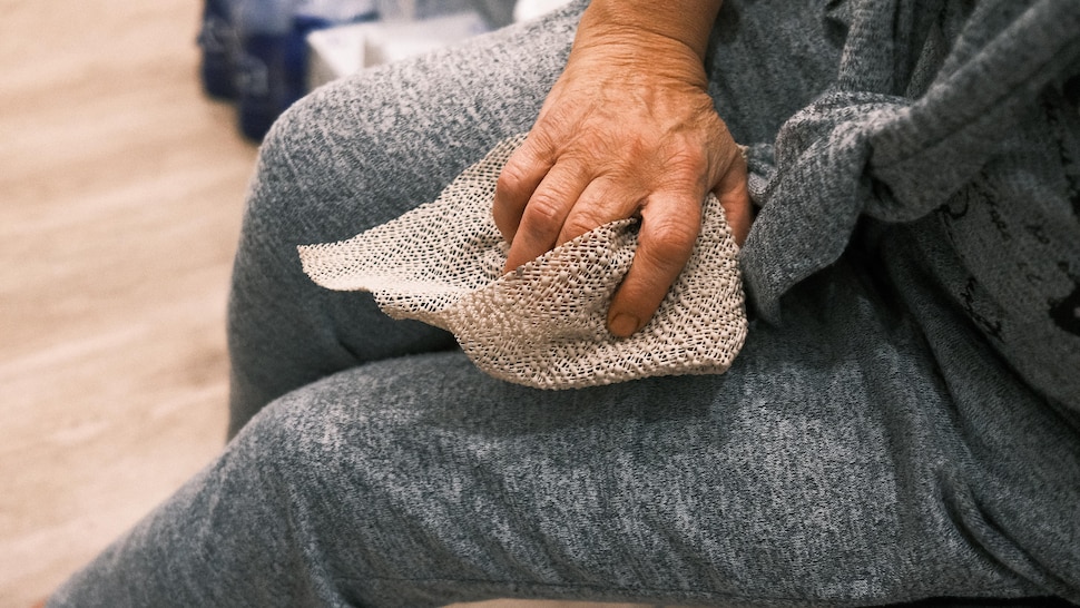 Une personne utilise un morceau de sous-tapis pour ouvrir un pot à une main.