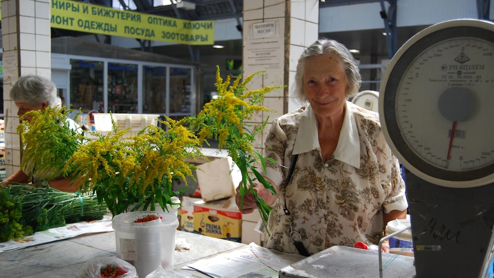 Femme qui vend des fleurs dans un marché de Saint-Pétersbourg.