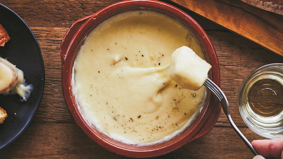 Un bol de fondue au fromage servi avec du pain.