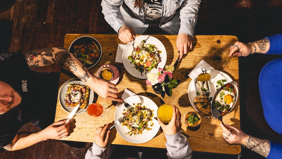 Quatre personnes à une table au Maelstrøm en train de manger.
