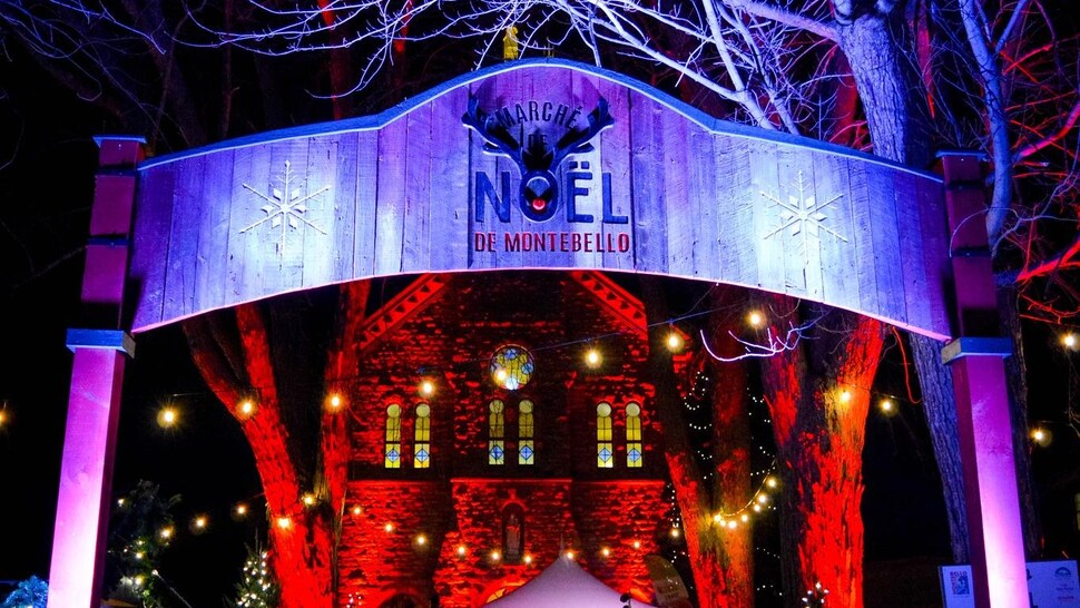L'entrée illuminée la nuit du marché de Noël de Montebello.