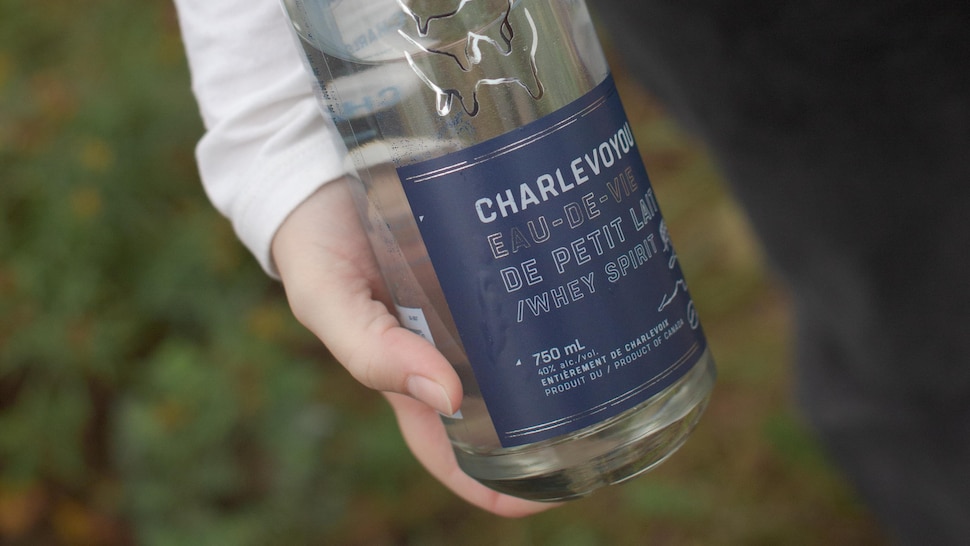 La bouteille d'eau-de-vie dans les mains d'une personne.