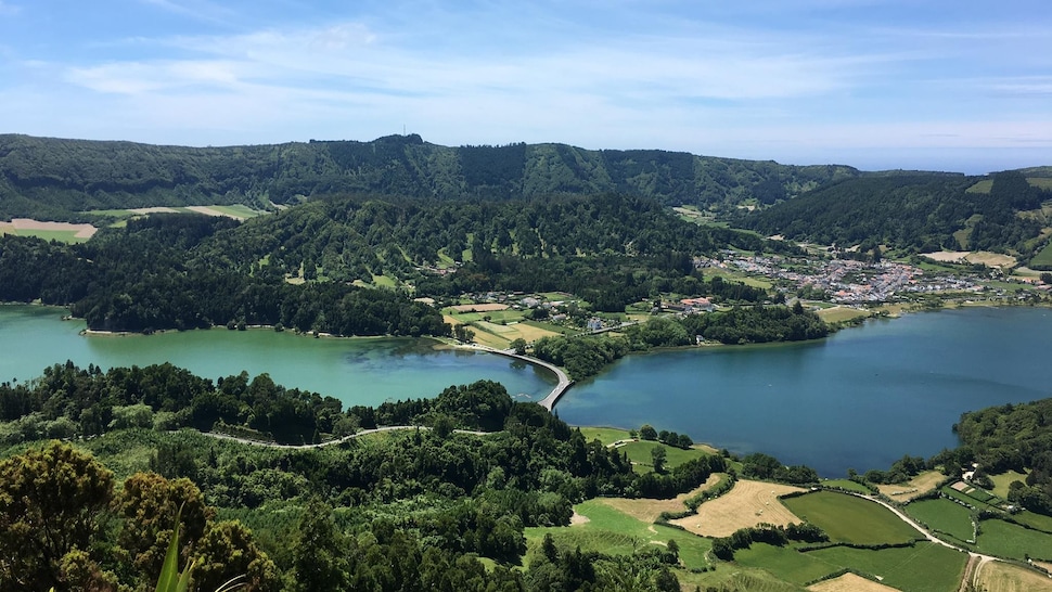 Un paysage montagneux et verdoyant séparé par un cours d'eau. 
