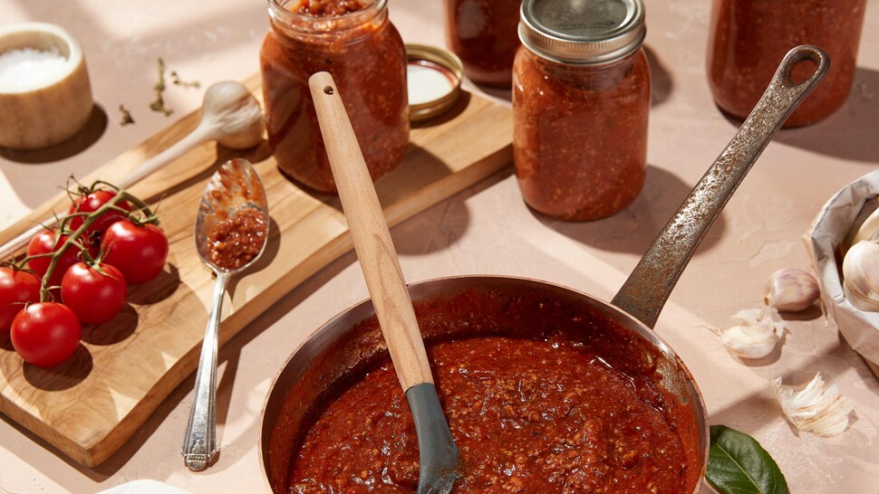 Une casserole et des pots Mason remplis de sauce bolognaise.