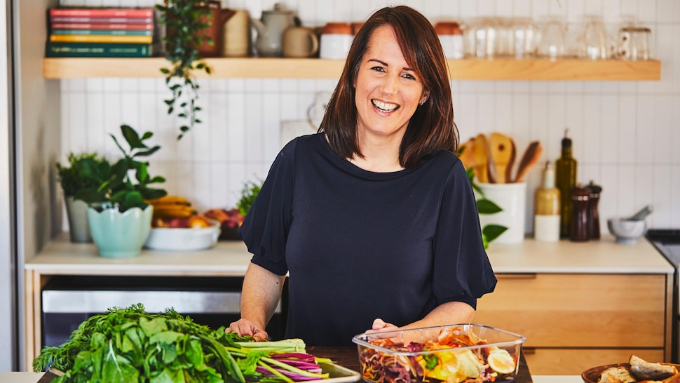 La nutritionniste Geneviève O'Gleman debout à l'îlot de cuisine avec des retailles de légumes devant elle. 