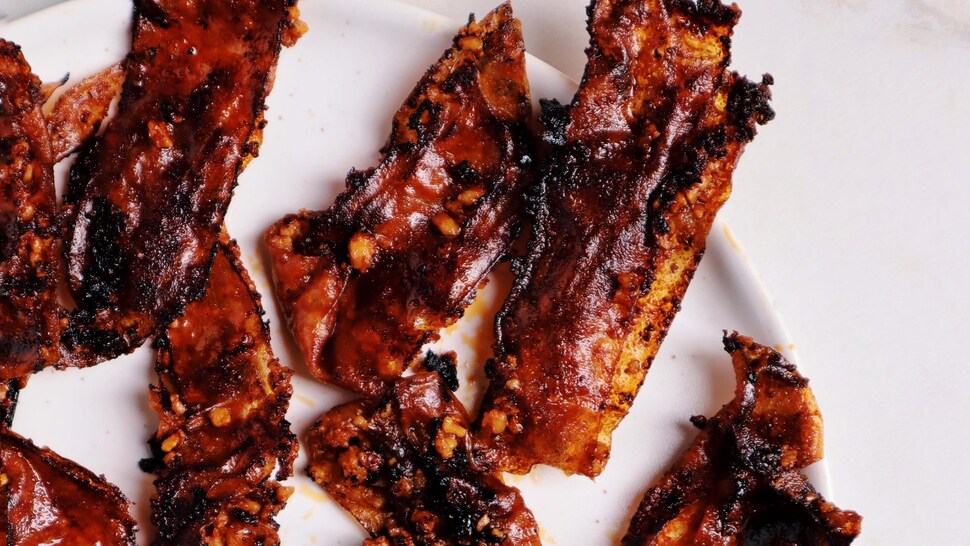 Des tranches de bacon végétalien étalées sur une assiette.