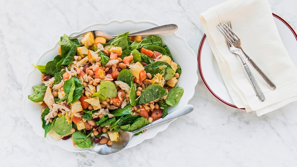 Un bol rempli de salade panzanella aux légumineuses et au poulet.
