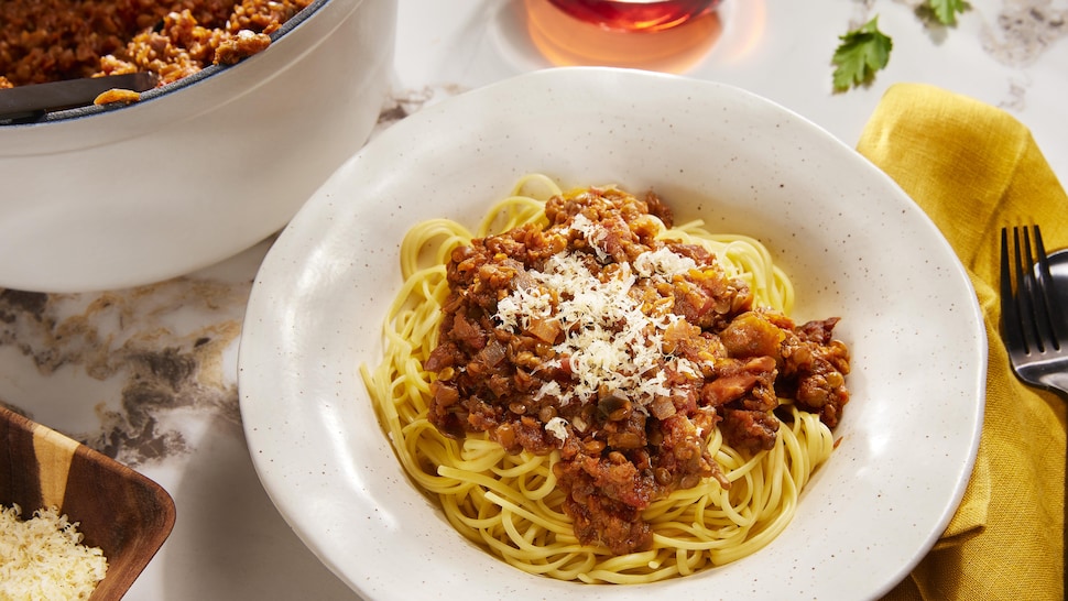 Un bol rempli de spaghetti avec une sauce bolognaise à l'aubergine et aux lentilles.