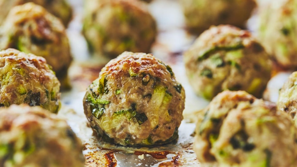 Des boulettes de dinde à la courgette sur une plaque de cuisson.