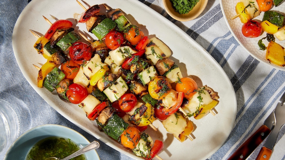 Des brochettes composées de morceaux de légumes (poivrons, oignons, courgettes, champignons, tomates) et de cubes d'halloumi.